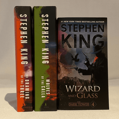 Cover of "Wizard and Glass, The Dark Tower, book 4", "Wolves of the Calla", and "The Drawing of the Three" by Stephen King.